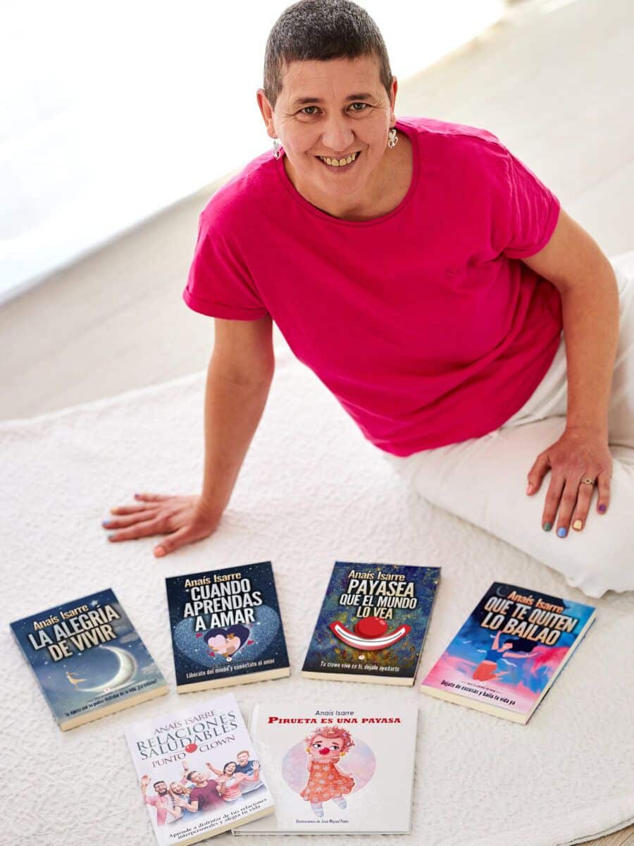 Anaís Isarre - Autora de la saga La Alegría de Vivir Anaís Isarre sentada en el suelo junto a sus 6 libros de desarrollo personal. Autora de la saga la Alegría de Vivir.