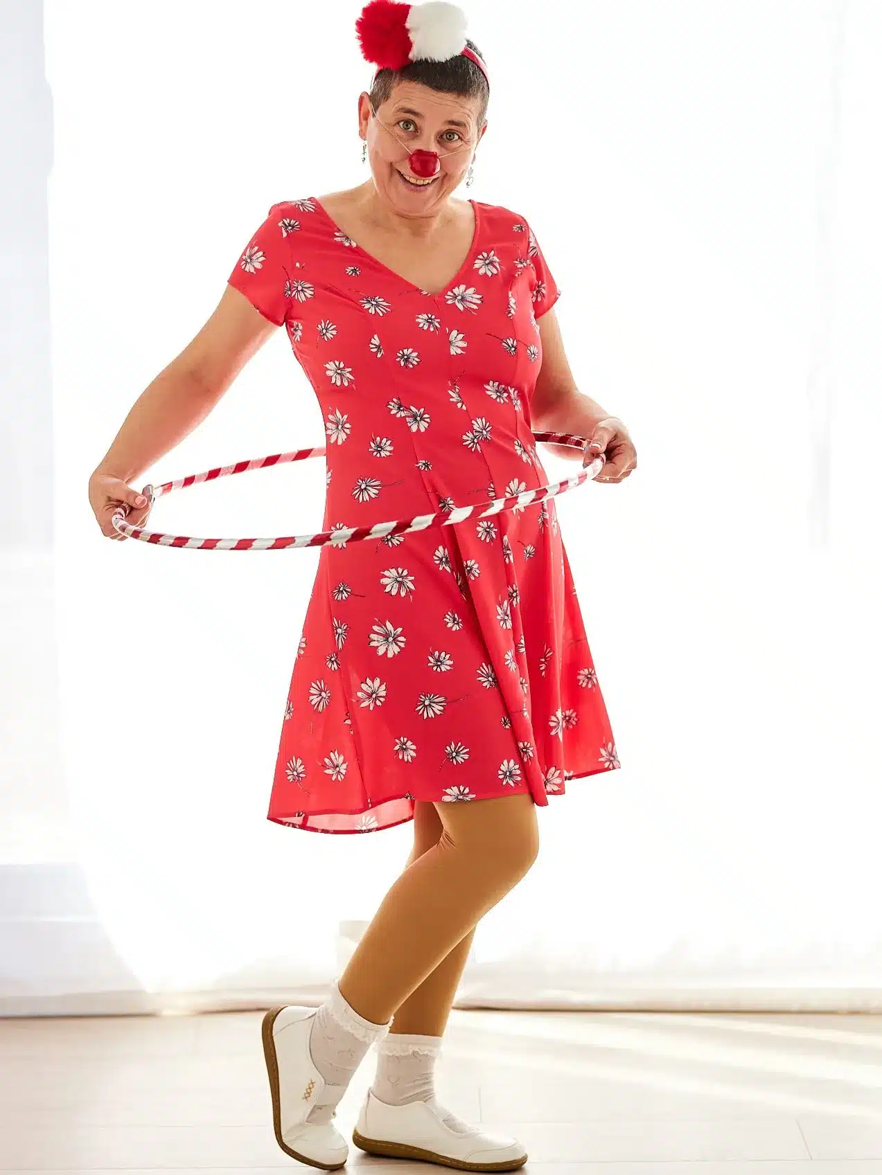 Pirueta y el hula hop - Escuela de Alegría Pirueta, la payasa interior de Anaís Isarre jugando con un hula hop y mirando a cámara.