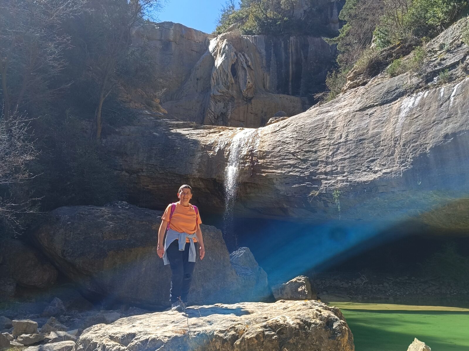 Anaís Isarre posando sobre una gran piedra delante de la Cascada del Confesionario conocida como Coño del Mundo en el Barranco de Sieste, Huesca.
